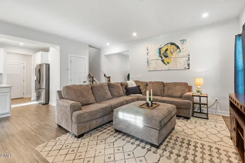a living room with furniture and a dining table with kitchen view