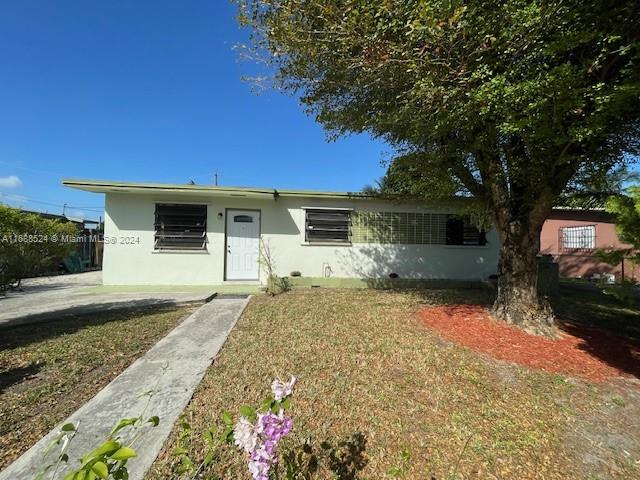 10791 Southwest 221st Street Miami, FL 33170 - Photo 2 of 18 a front view of a house with a yard and garage