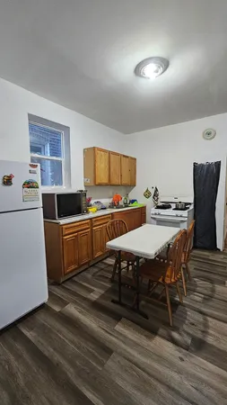 a kitchen with a table chairs a stove and a refrigerator