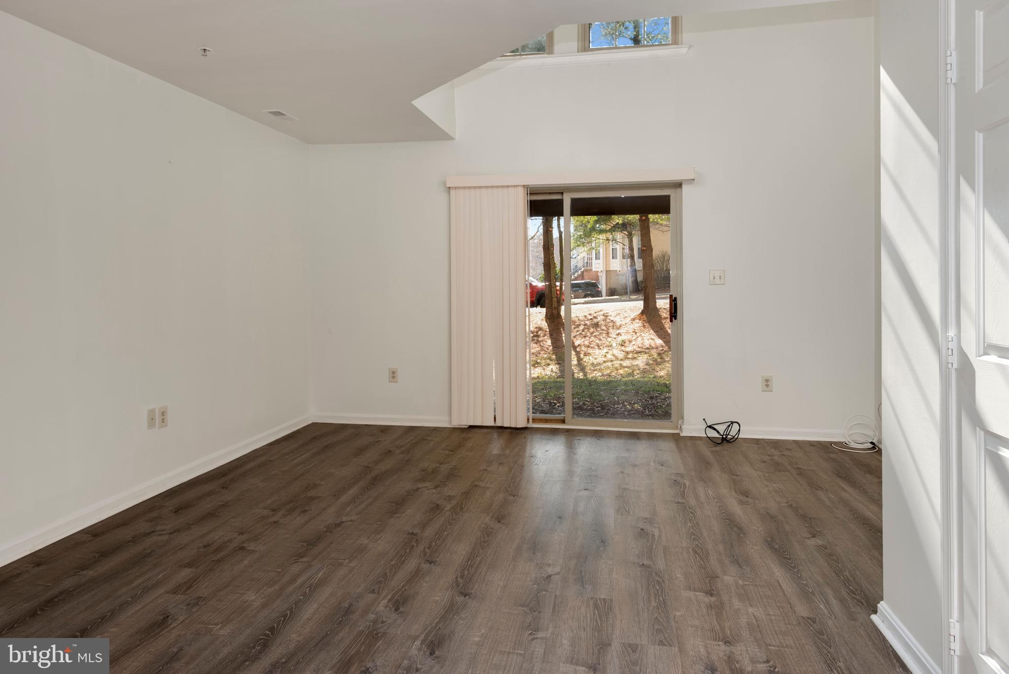 43 Bank Spring Court Owings Mills, MD 21117 - Photo 4 of 27 an empty room with wooden floor and windows
