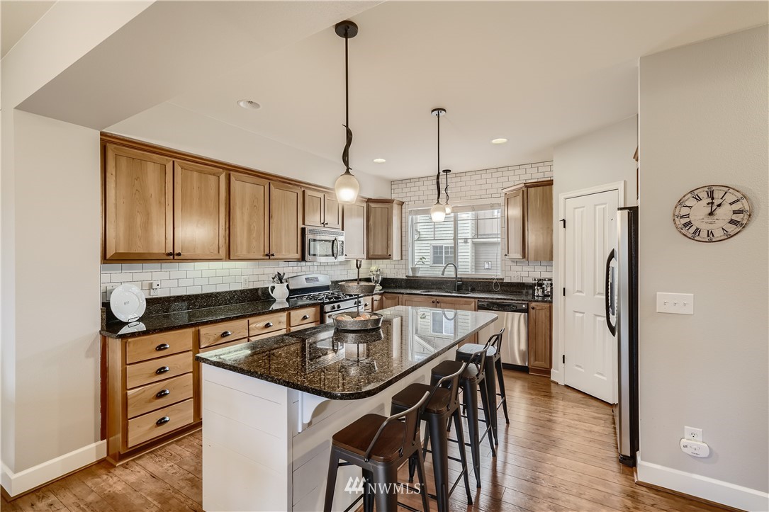 320 Chelan Place Northeast, Unit H3 Renton, WA 98059 - Photo 11 of 28 a kitchen with stainless steel appliances granite countertop a sink a stove and a refrigerator