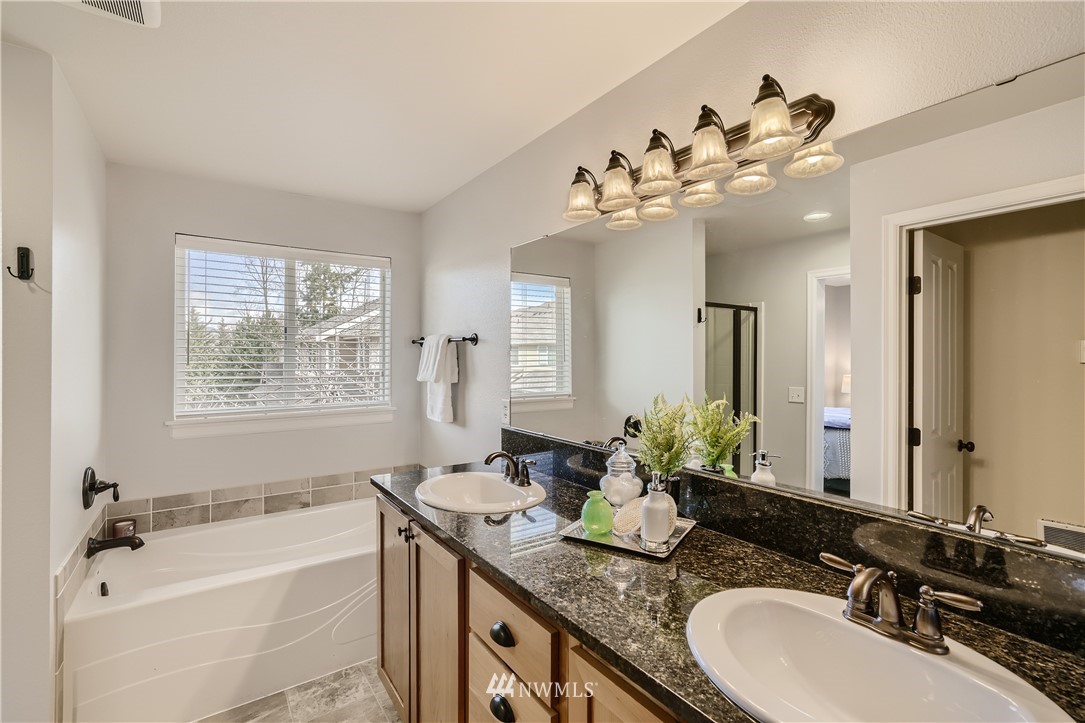 320 Chelan Place Northeast, Unit H3 Renton, WA 98059 - Photo 17 of 28 a bathroom with a granite countertop sink a large mirror and a bathtub