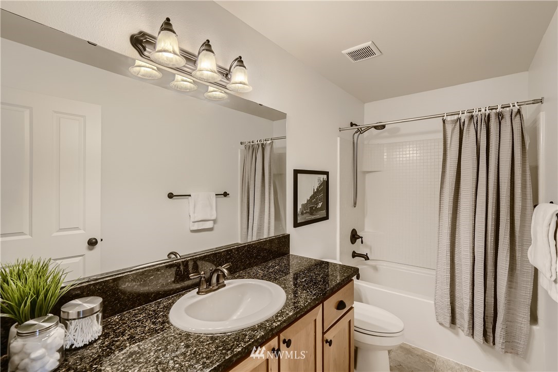 320 Chelan Place Northeast, Unit H3 Renton, WA 98059 - Photo 21 of 28 a bathroom with a granite countertop sink a toilet a mirror and shower