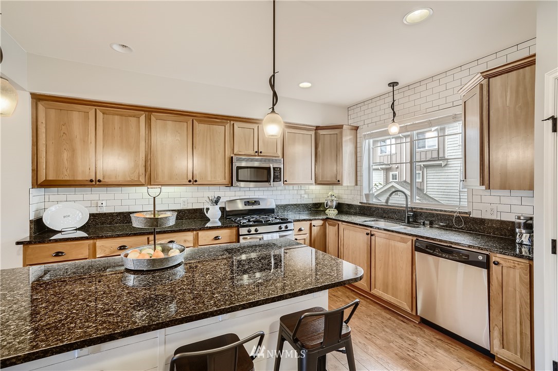 320 Chelan Place Northeast, Unit H3 Renton, WA 98059 - Photo 10 of 28 a kitchen with stainless steel appliances granite countertop a sink a stove and cabinets