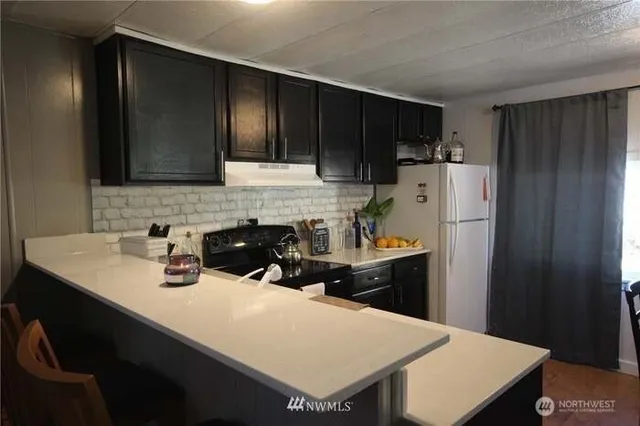 a kitchen with a refrigerator a sink and cabinets