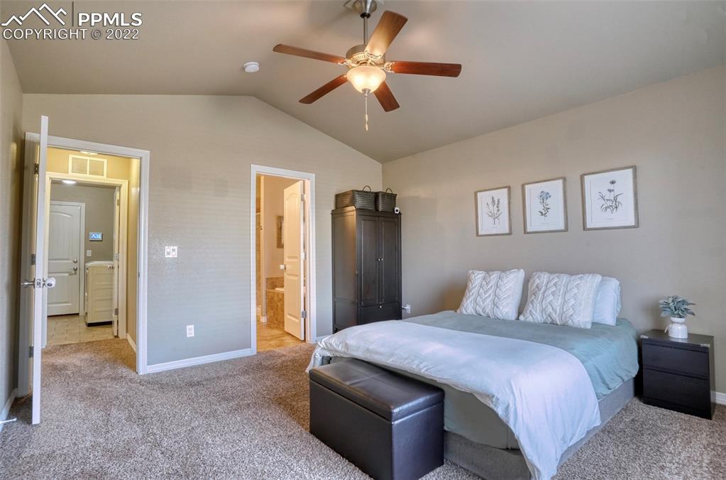 6729 Kearsarge Drive Colorado Springs, CO 80925 - Photo 8 of 22 a bedroom with a bed and a chandelier
