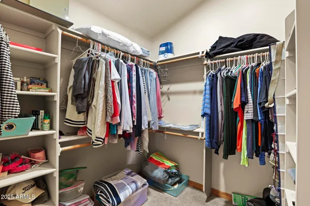 a view of walk in closet with clothes and shoes