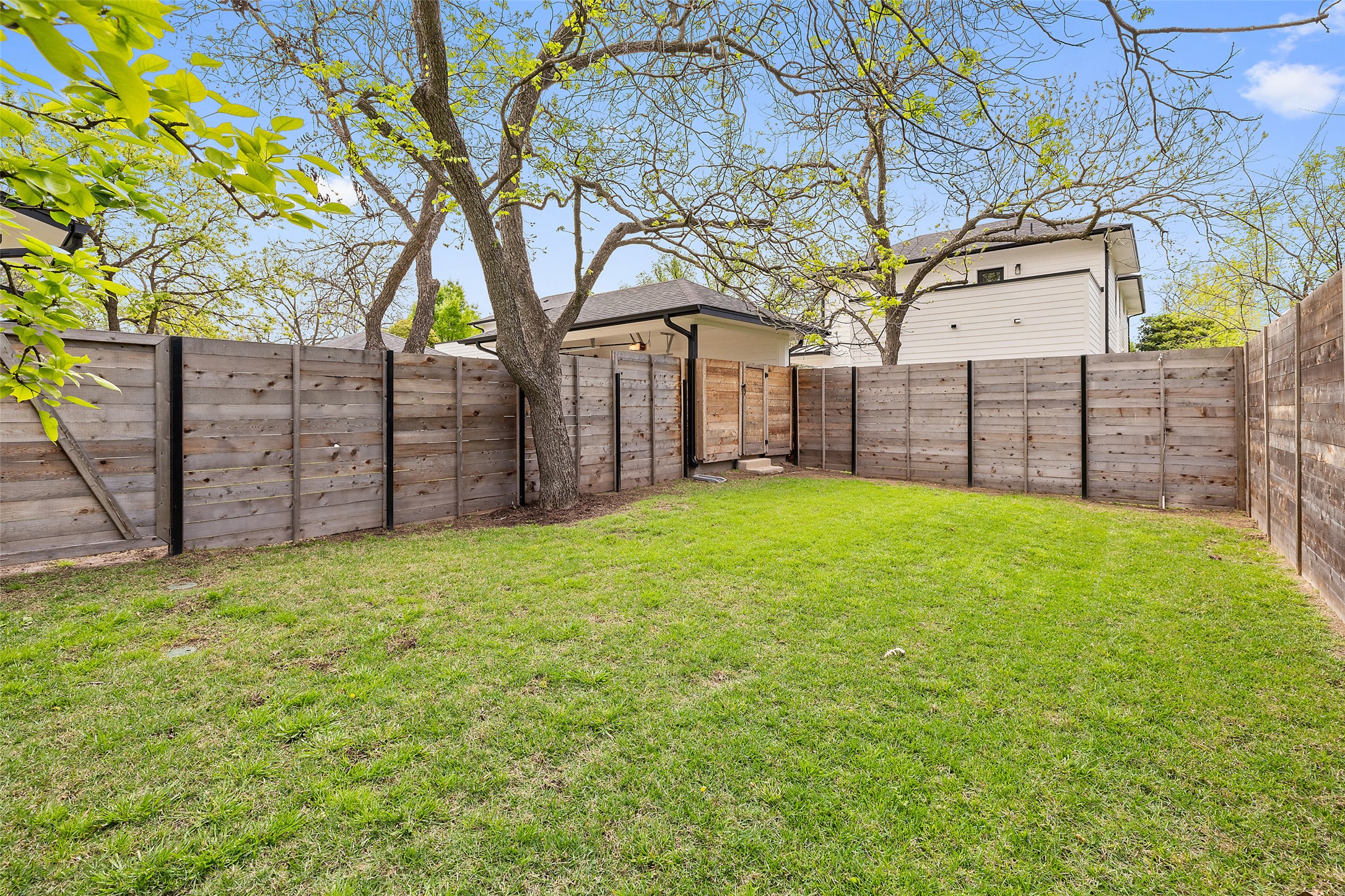 1504 Ruth Avenue, Unit 3 Austin, TX 78757 - Photo 35 of 39 A well-maintained lawn is bordered by a modern privacy fence, perfect for quiet outdoor enjoyment.