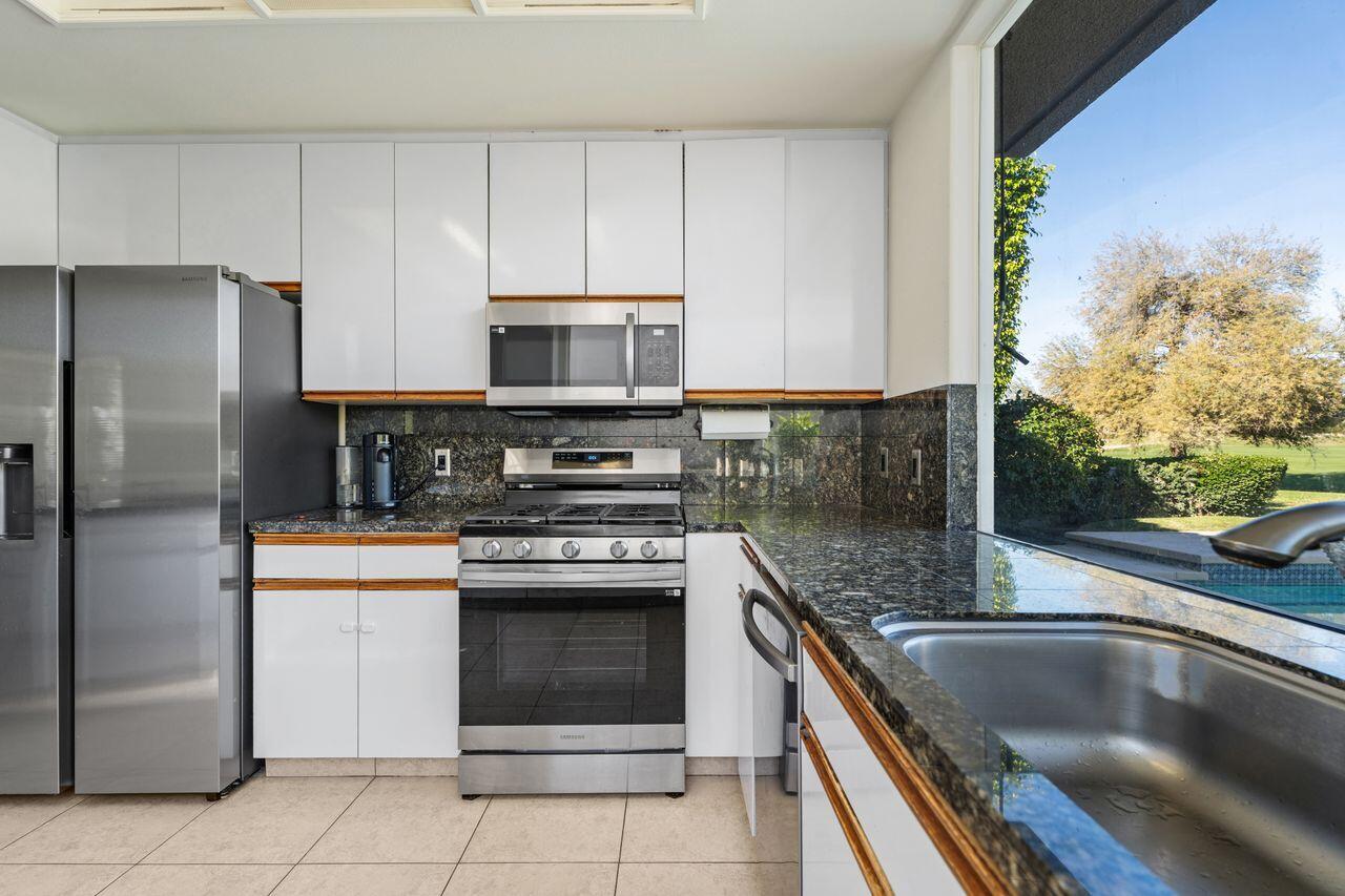 6 Pebble Beach Drive Rancho Mirage, CA 92270 - Photo 14 of 46 a kitchen with stainless steel appliances granite countertop a stove a refrigerator and a microwave