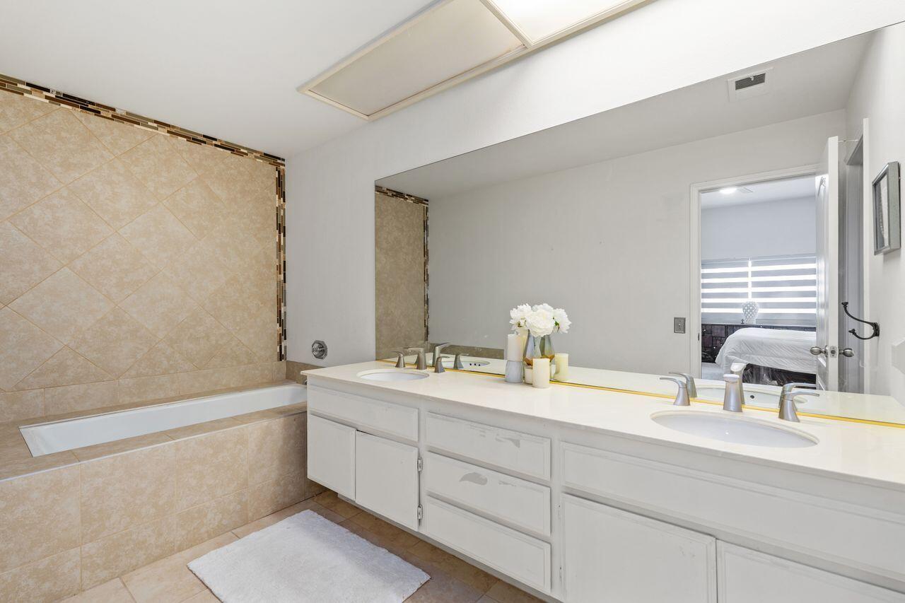 6 Pebble Beach Drive Rancho Mirage, CA 92270 - Photo 16 of 44 a bathroom with a double vanity sink window and a bathtub