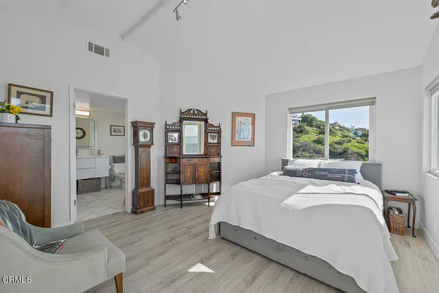 a bedroom with a bed and large windows