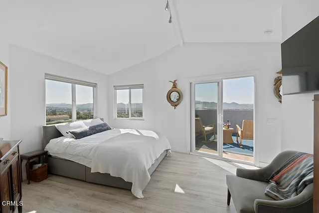 a roof deck with table and chairs and potted plants