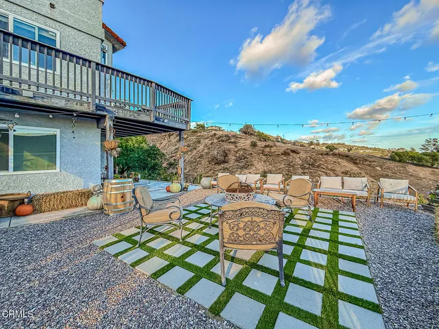a view of a patio with table and chairs with wooden floor and fence