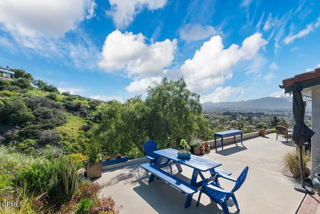 an aerial view of a house with a yard and mountain view in back
