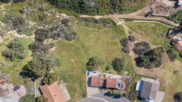 an aerial view of residential houses with outdoor space and trees