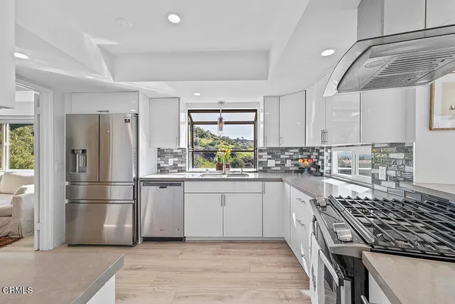 a kitchen with granite countertop a refrigerator stove top oven and sink