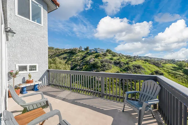 a view of a balcony with couches and wooden floor