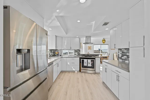 a kitchen with white cabinets and stainless steel appliances