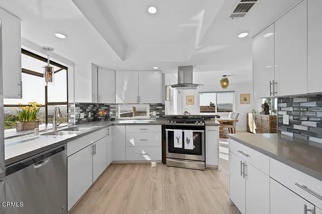 a kitchen with sink a stove and cabinets