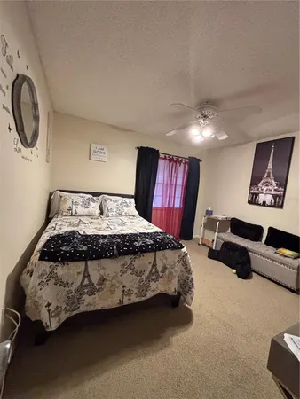 a spacious bedroom with a bed a mirror and a window