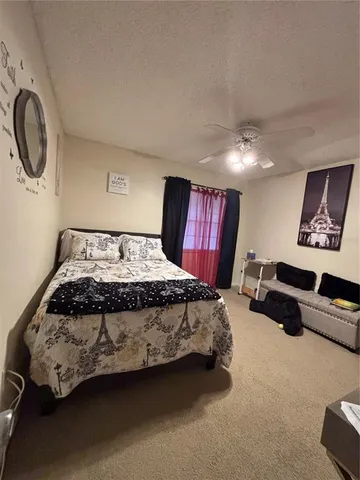 a spacious bedroom with a bed a mirror and a window