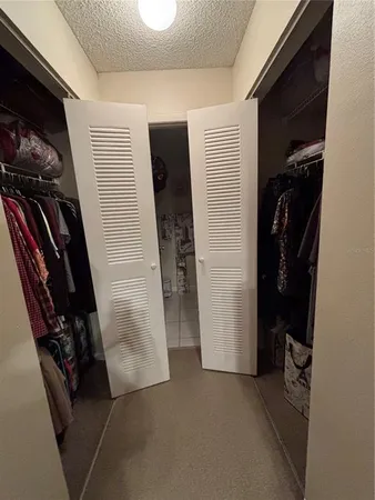 a view of walk in closet with clothes and shoes