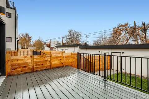 a view of a balcony with wooden floor and iron fence