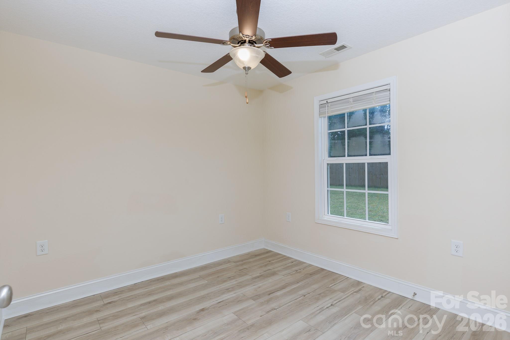 3692 Armstrong Ford Road Rock Hill, SC 29730 - Photo 18 of 30 an empty room with wooden floor ceiling fan and windows