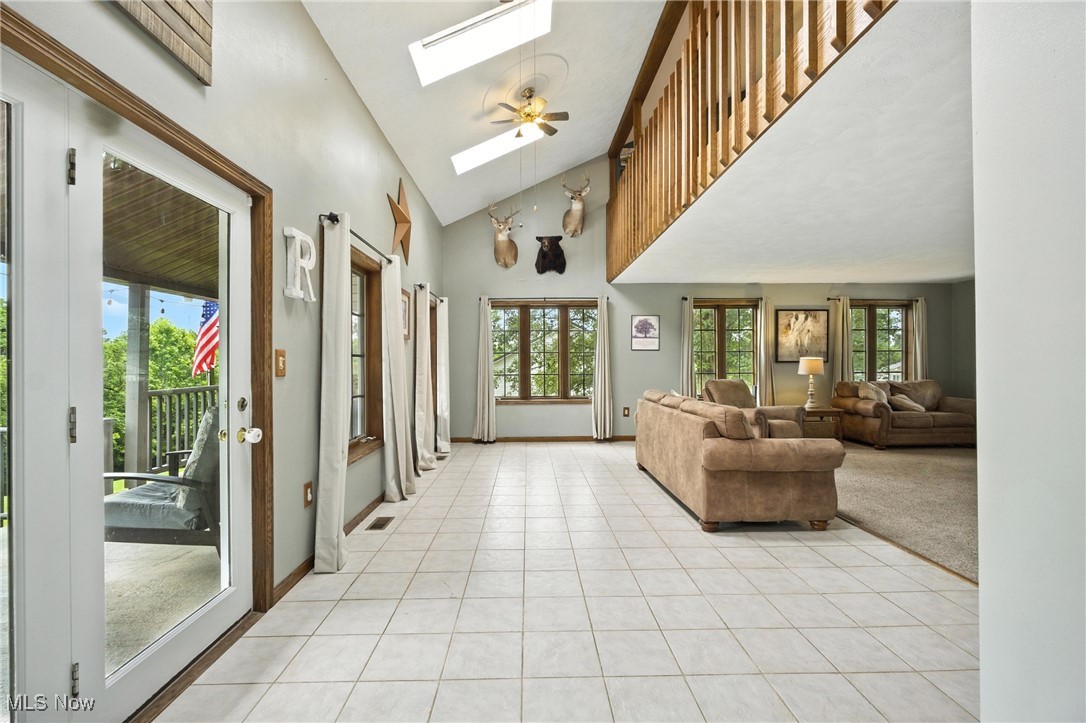 1371 Spider Ridge Road Parkersburg, WV 26104 - Photo 7 of 48 Entryway featuring a skylight, light tile patterned floors, and high vaulted ceiling
