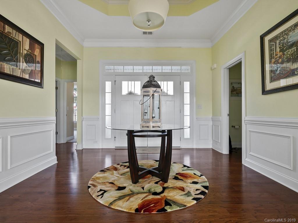 1821 Larkspur Way Tega Cay, SC 29708 - Photo 2 of 26 a dining room with wooden floor a glass table and chairs