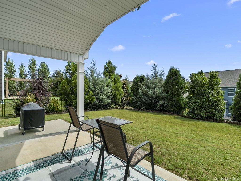1821 Larkspur Way Tega Cay, SC 29708 - Photo 24 of 26 a view of a patio with table and chairs potted plants with wooden floor