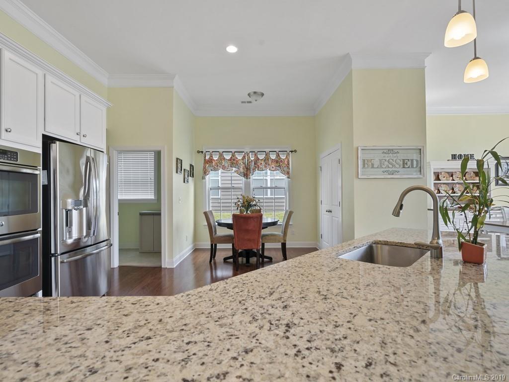 1821 Larkspur Way Tega Cay, SC 29708 - Photo 9 of 26 a kitchen with stainless steel appliances kitchen island granite countertop a refrigerator and a sink