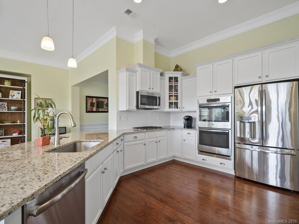 1821 Larkspur Way Tega Cay, SC 29708 - Photo 10 of 26 a kitchen with granite countertop stainless steel appliances a refrigerator sink and microwave