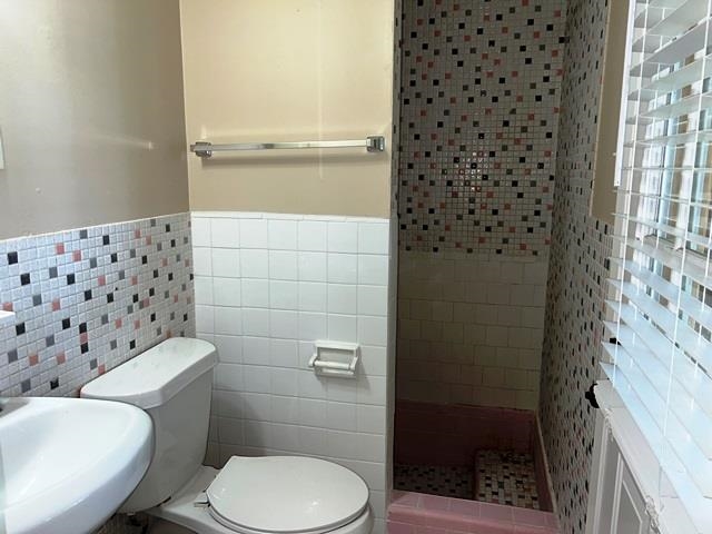 5183 Sea Shore Road Memphis, TN 38109 - Photo 12 of 17 Bathroom featuring sink, toilet, a tile shower, and tile walls