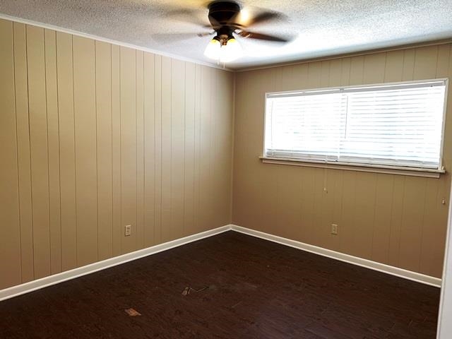 5183 Sea Shore Road Memphis, TN 38109 - Photo 10 of 17 Empty room featuring a textured ceiling, ceiling fan, and dark hardwood / wood-style floors