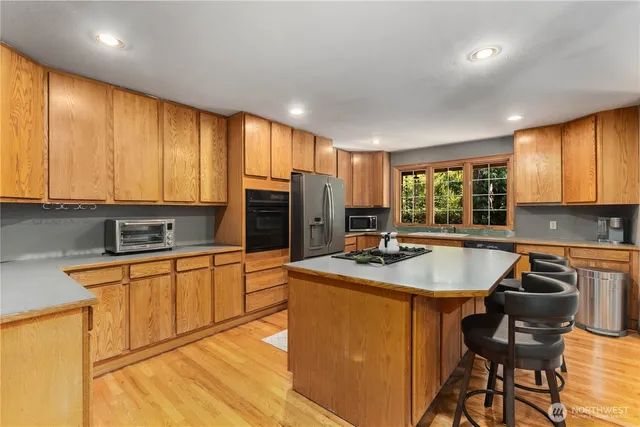 a kitchen with stainless steel appliances granite countertop sink stove top oven and cabinets