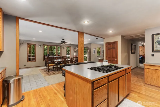 a kitchen with stainless steel appliances granite countertop a stove a sink dishwasher and a refrigerator with wooden floor