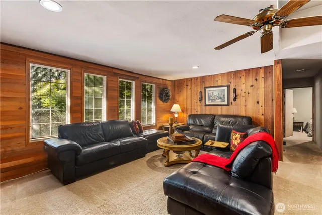 a living room with furniture ceiling fan and a window