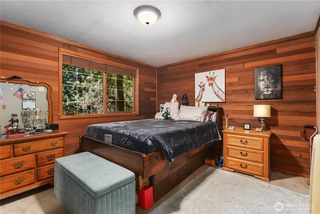 a bedroom with a bed and a dresser next to a window