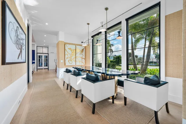a kitchen with stainless steel appliances kitchen island a large white table chairs and a refrigerator
