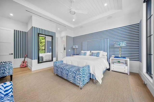 a living room with a black white checkered floor with a gaming machine and dining chairs