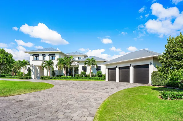 a front view of a house with a yard and potted plants