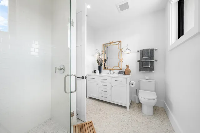 a bathroom with a sink vanity mirror and toilet