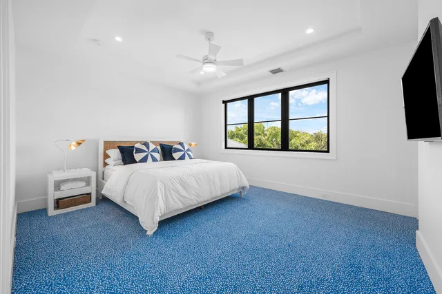 a bedroom with a bed and a table in it with wooden floor