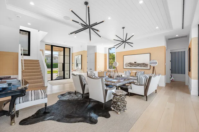 a living room with furniture a large window and a chandelier