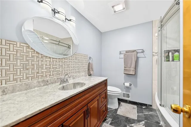 a spacious bedroom with a bed a dresser and next to a window