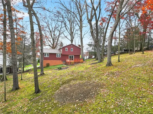 an aerial view of residential houses with outdoor space and trees