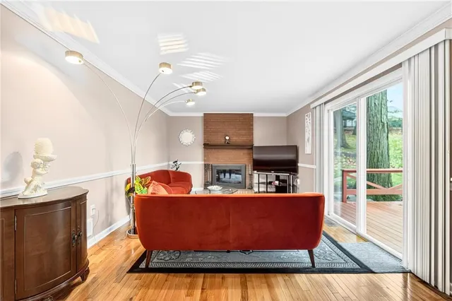 a living room with furniture kitchen view and a large window