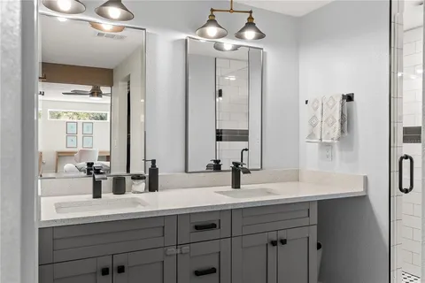 a bathroom with double vanity and a mirror