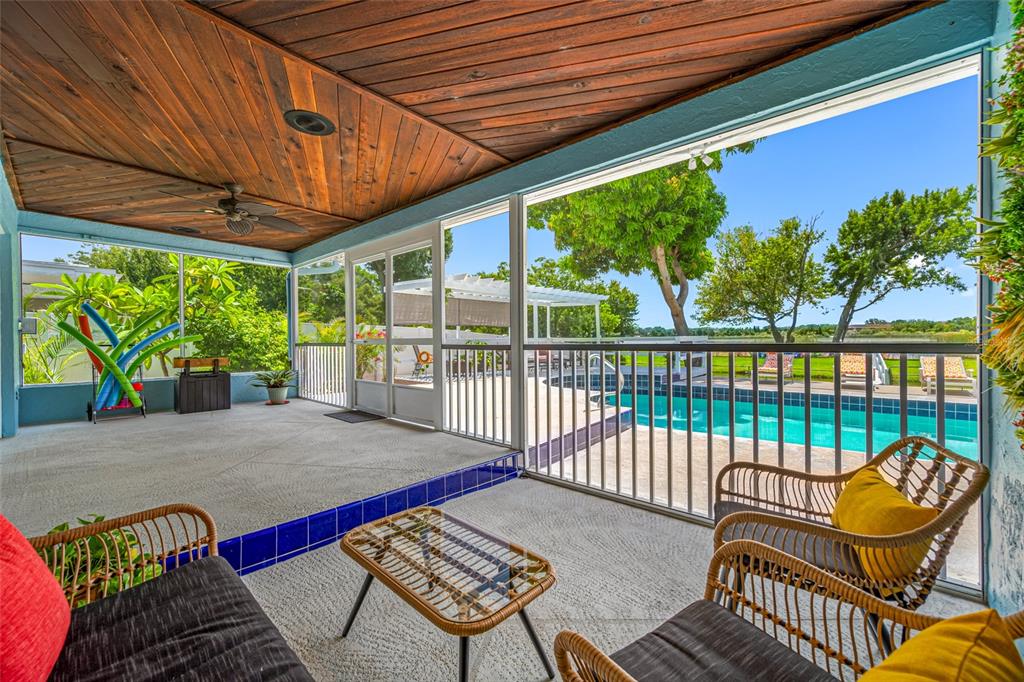 2153 Karan Way Clearwater, FL 33763 - Photo 45 of 65 a view of a patio with table and chairs potted plants with wooden floor and floor to ceiling window